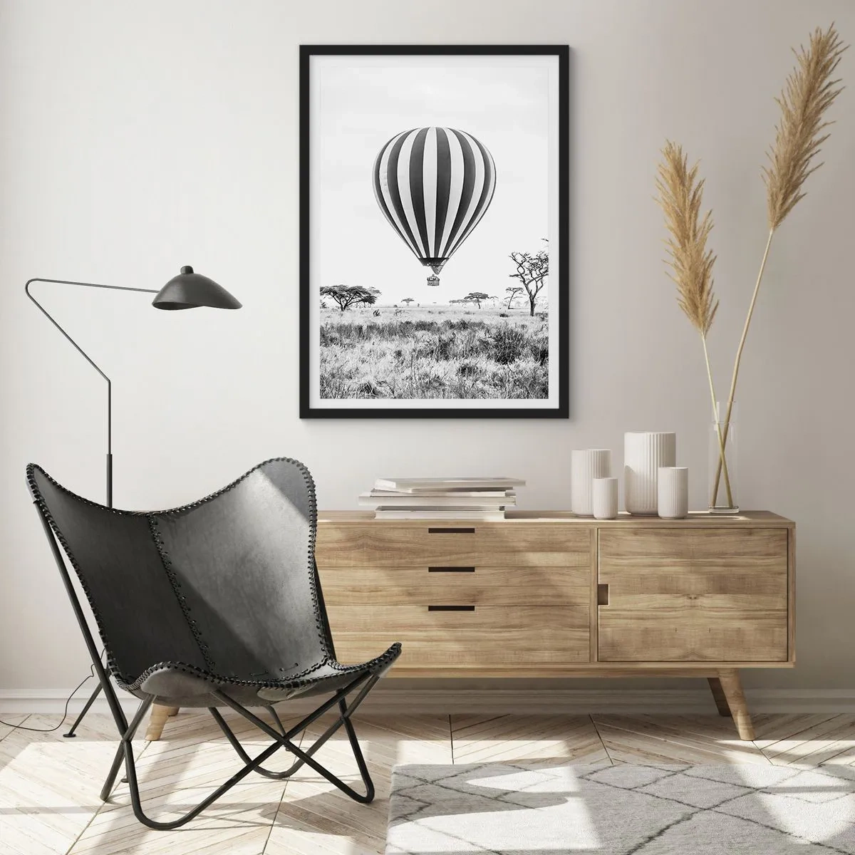 Affiche dans un cadre noir - Poster - Une montgolfière flottant au-dessus de la savane en noir et blanc. - 50x70cm - Au dessus de la savane - Décoration murale moderne pour le salon et la chambre ARTTOR